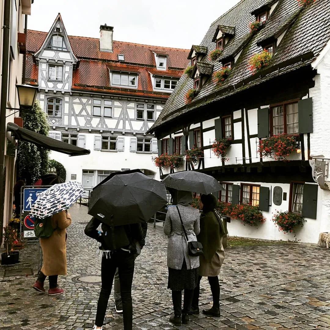 Gruppe mit Regenschirmen spaziert durch die Ulmer Altstadt