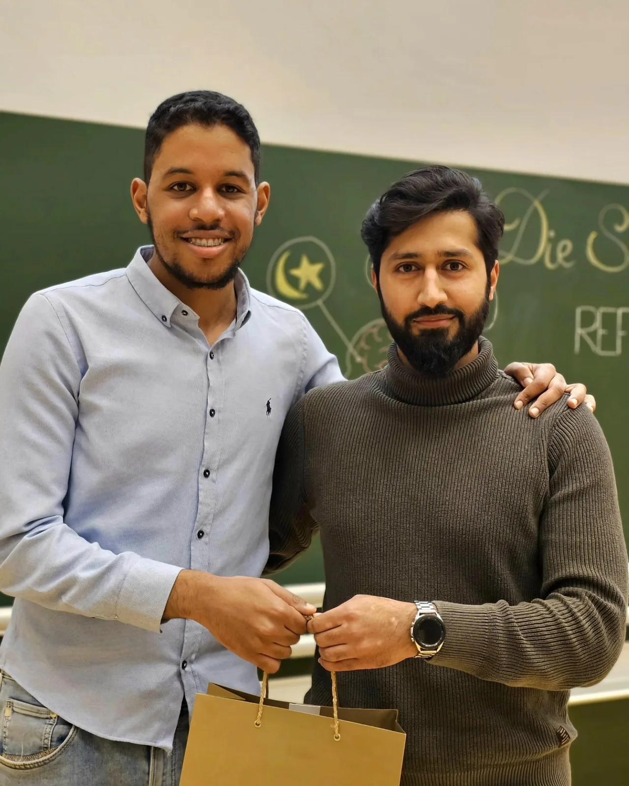 Zwei Männer umarmen sich freundschaftlich mit einem Geschenk in der Hand