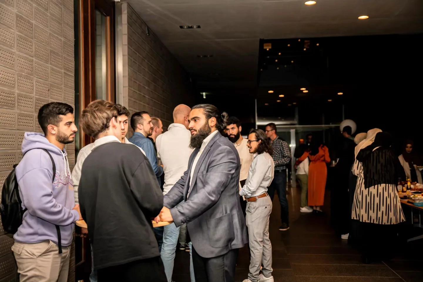 Gäste stehen im Foyer zusammen und kommen ins Gespräch