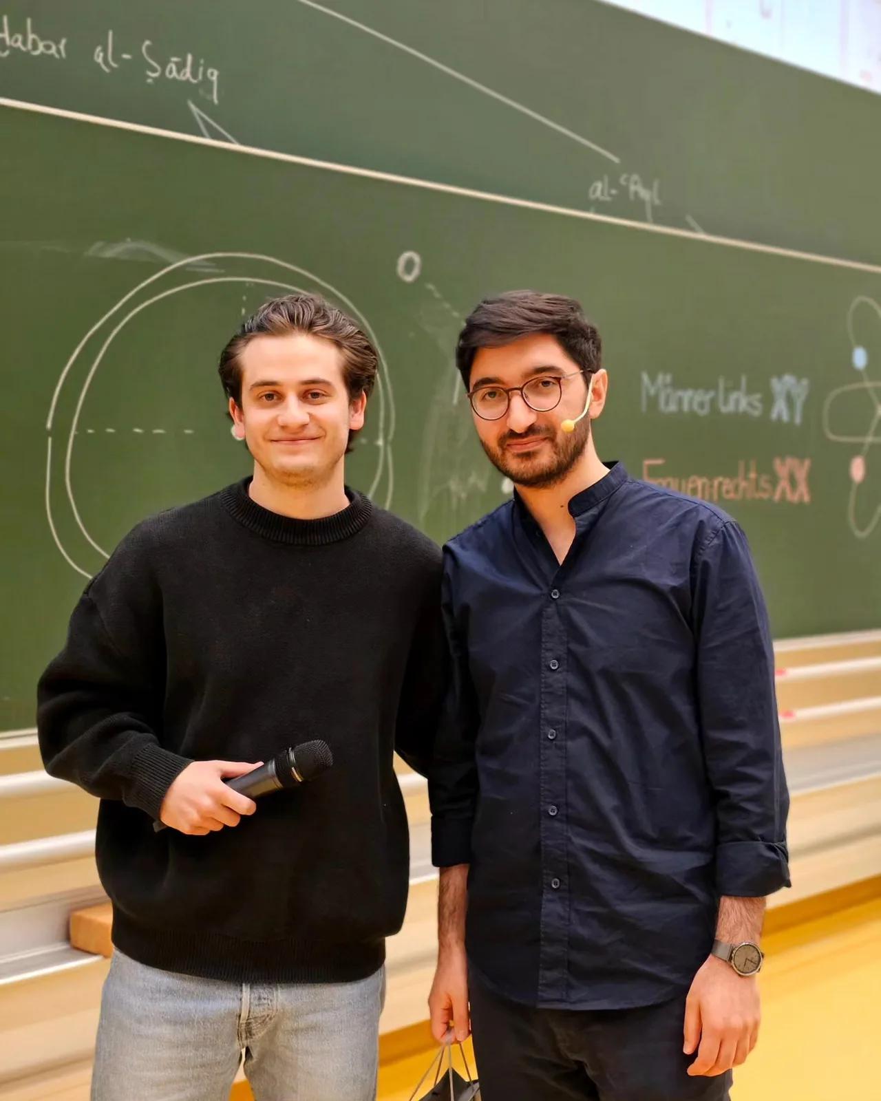 Zwei Freunde machen lachend ein Selfie im Hörsaal