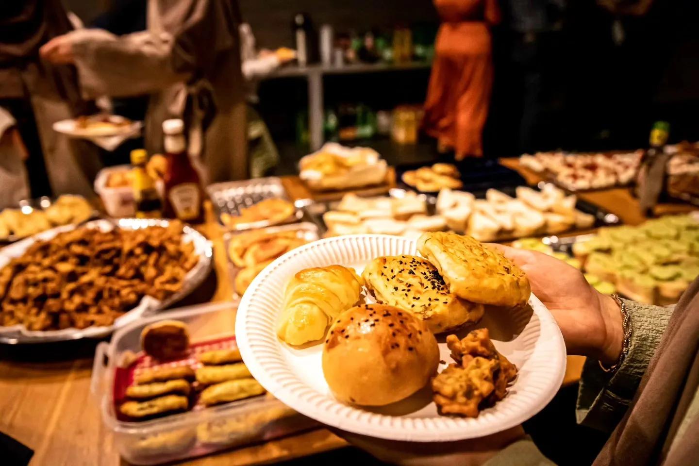 Teller mit Croissants und herzhaftem Gebäck auf langem Buffettisch