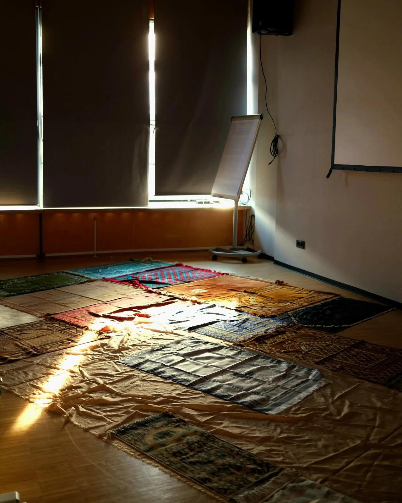 Bunte Lichtreflexe fallen auf den gemusterten Teppich des Gebetsraums