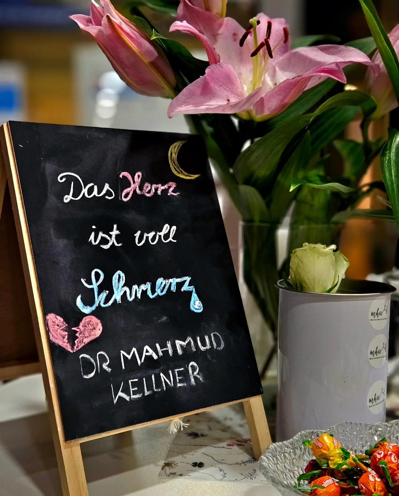 Kreidetafel Das Herz ist voll Schmerz neben Blumenvase