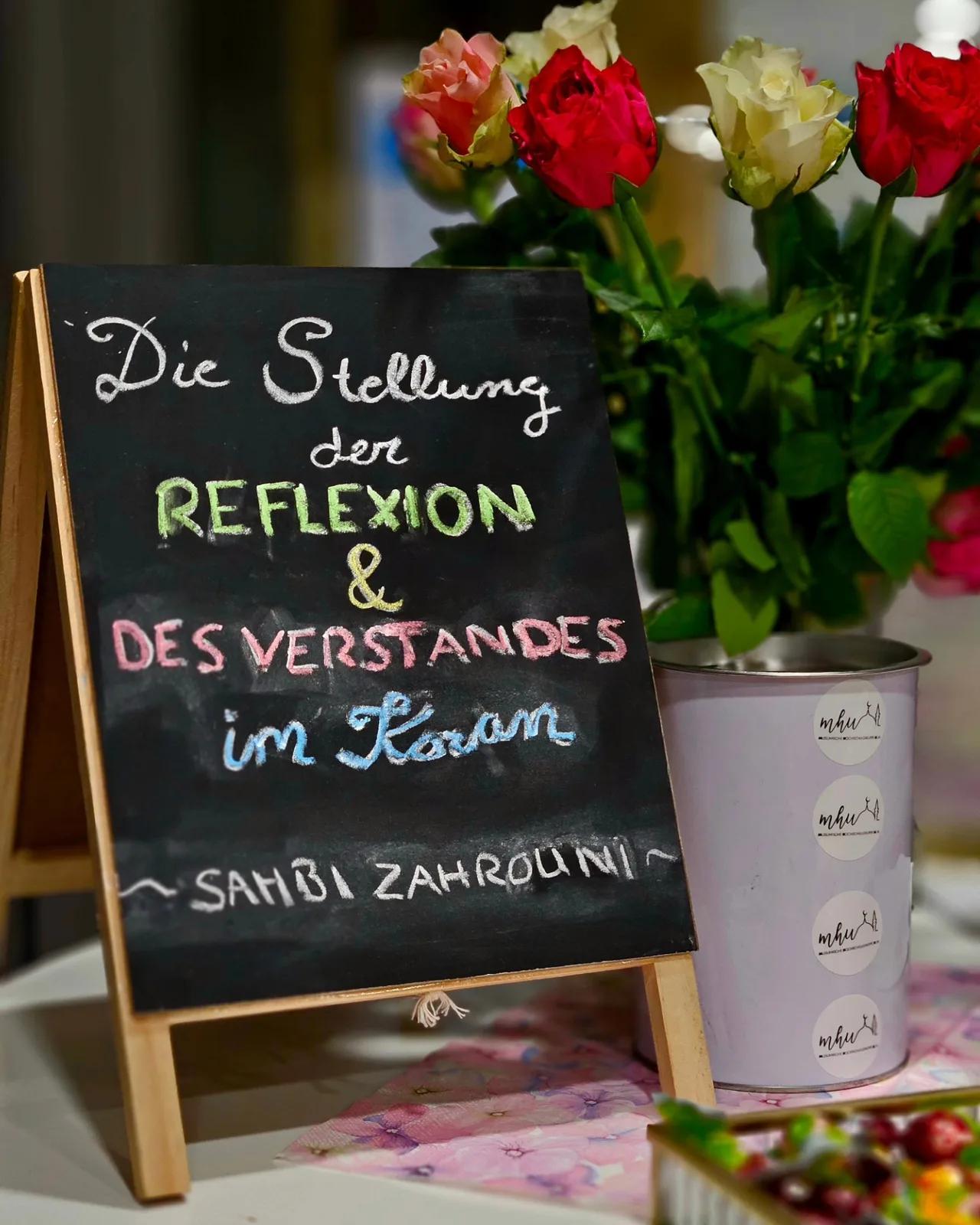 Tafel zur Stellung der Reflexion neben Blumenstrauß und Grünpflanze