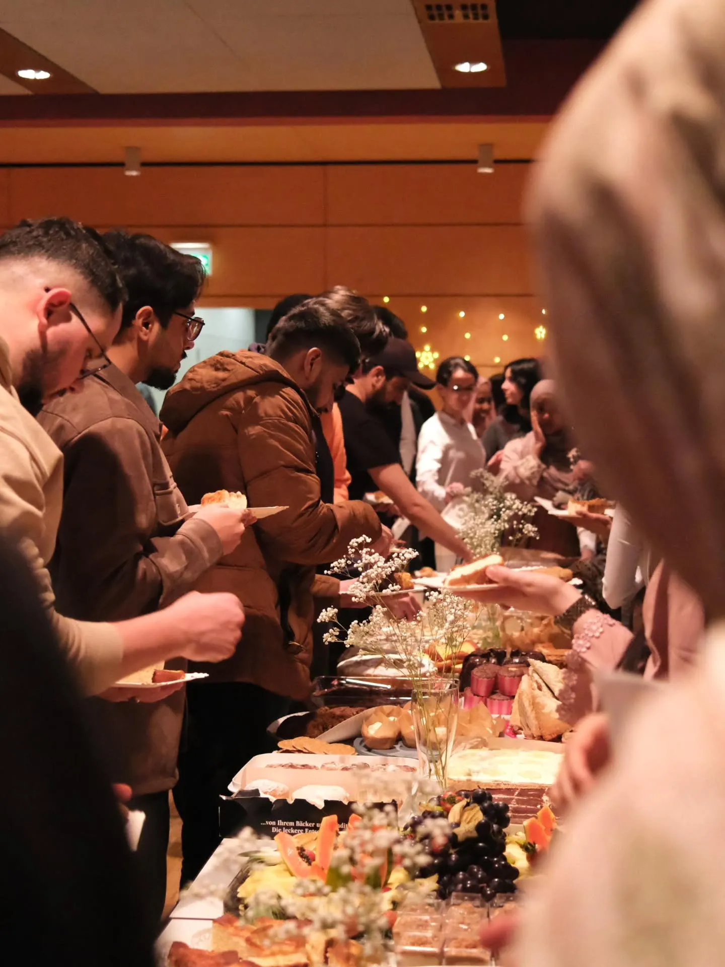 Studierende stehen am Buffet bei einem MHU-Iftar.