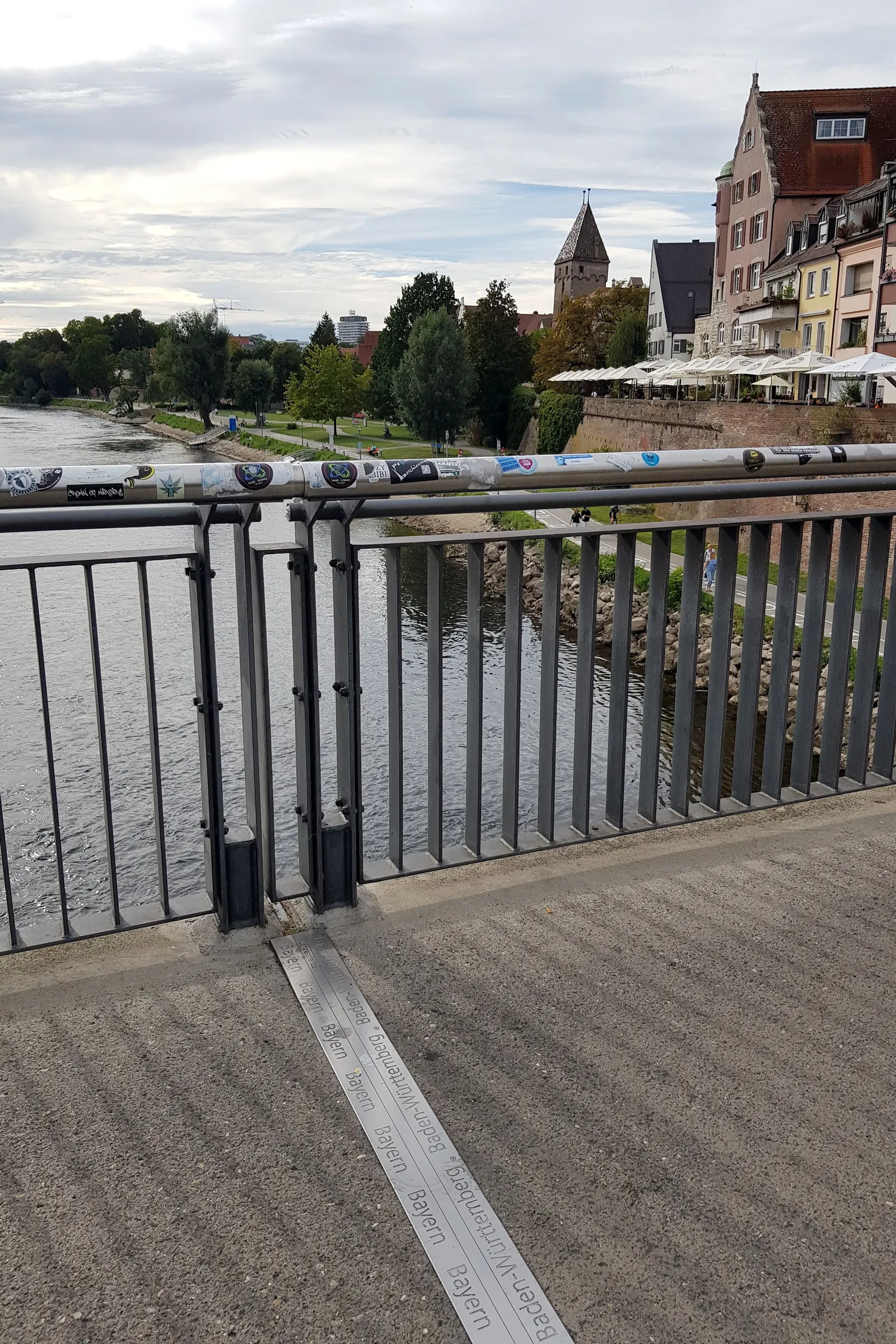 Gehweg auf der Herdbrücke mit einer Markierung im Boden, die die Grenze zwischen Baden-Württemberg und Bayern anzeigt