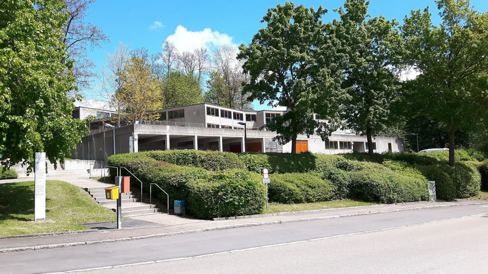 Die flachen Betonbauten der ehemaligen Hochschule für Gestaltung am Kuhberg zwischen Bäumen