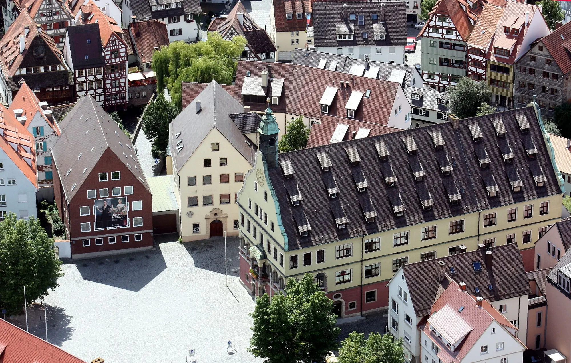 Blick von oben auf das bemalte Ulmer Rathaus und die Giebel der umliegenden Altstadthäuser