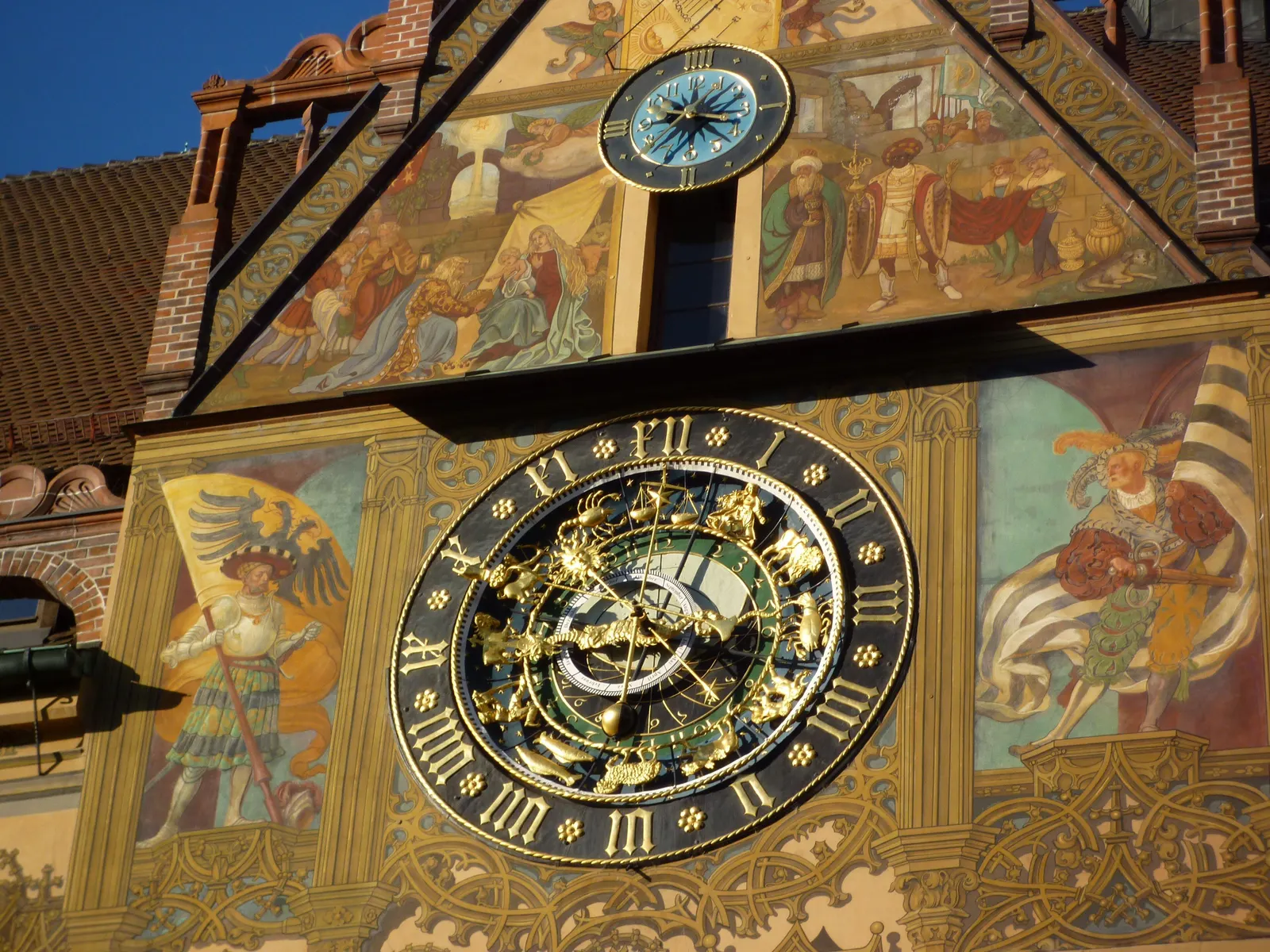 Die goldene astronomische Uhr an der bemalten Fassade des Ulmer Rathauses