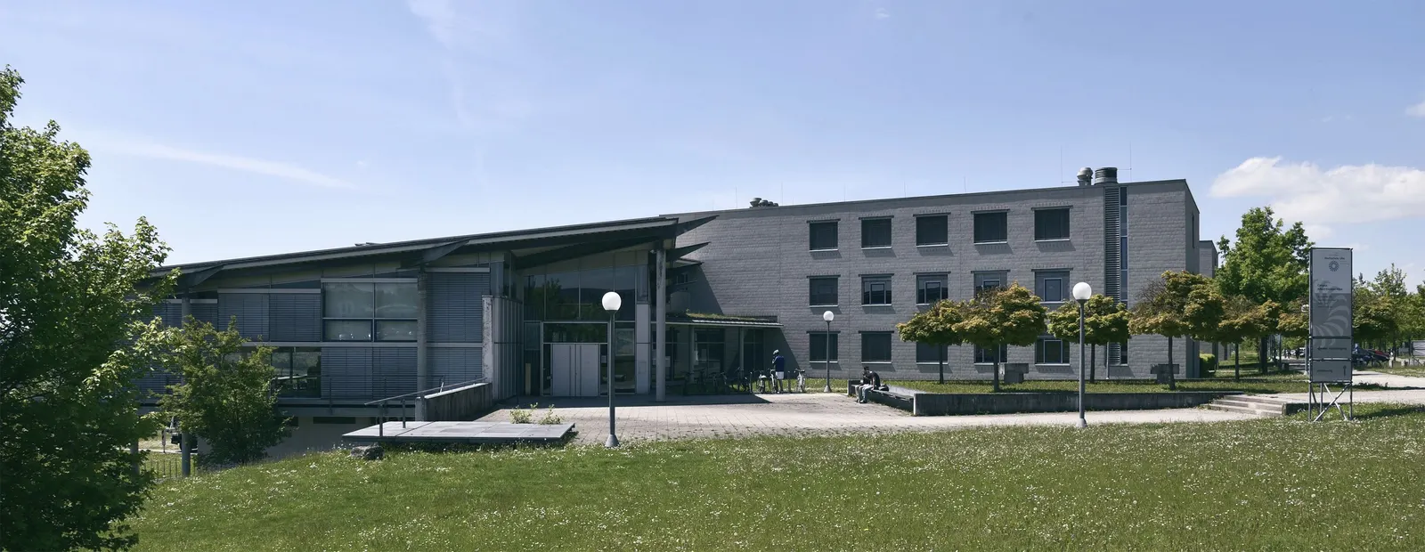 Die Gebäude der Technischen Hochschule Ulm am Campus Albert-Einstein-Allee hinter einer Rasenfläche