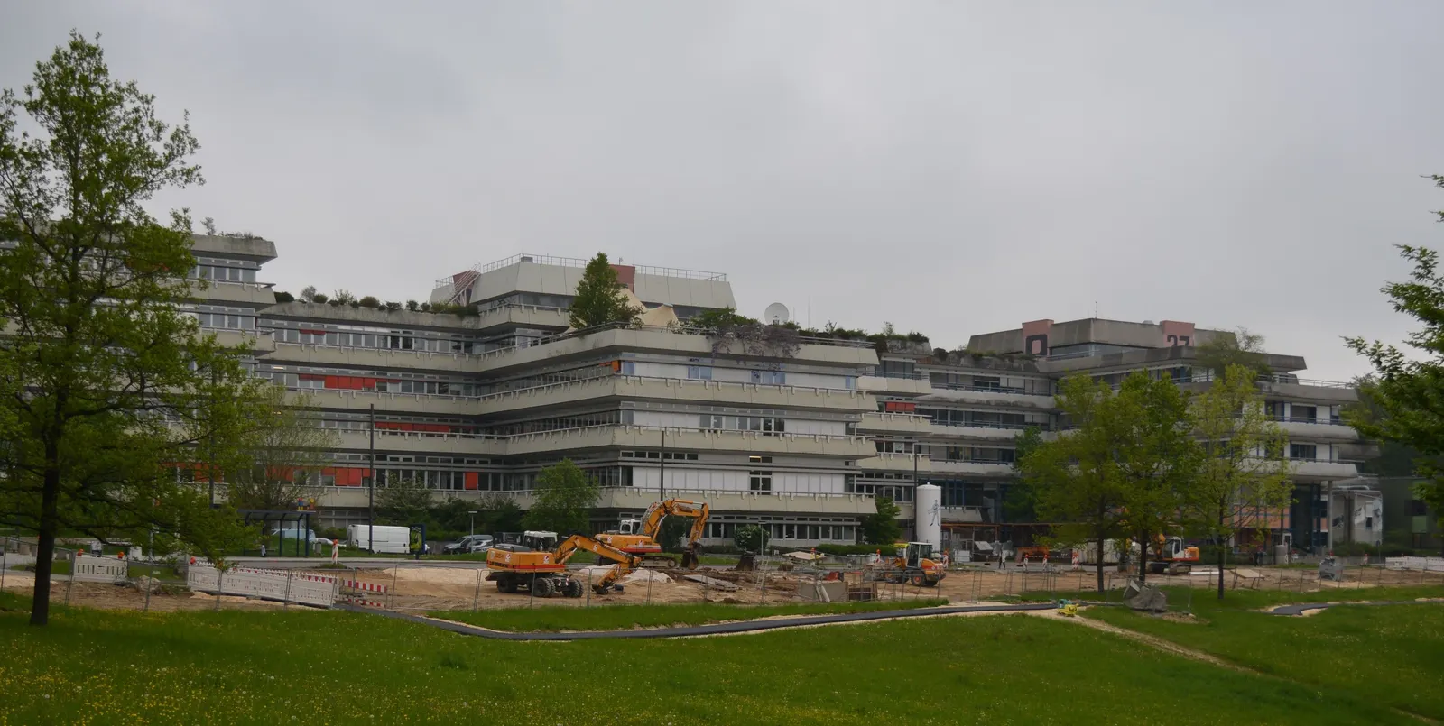 Die gestaffelten Gebäude der Universität Ulm auf dem Oberen Eselsberg hinter einer Wiese